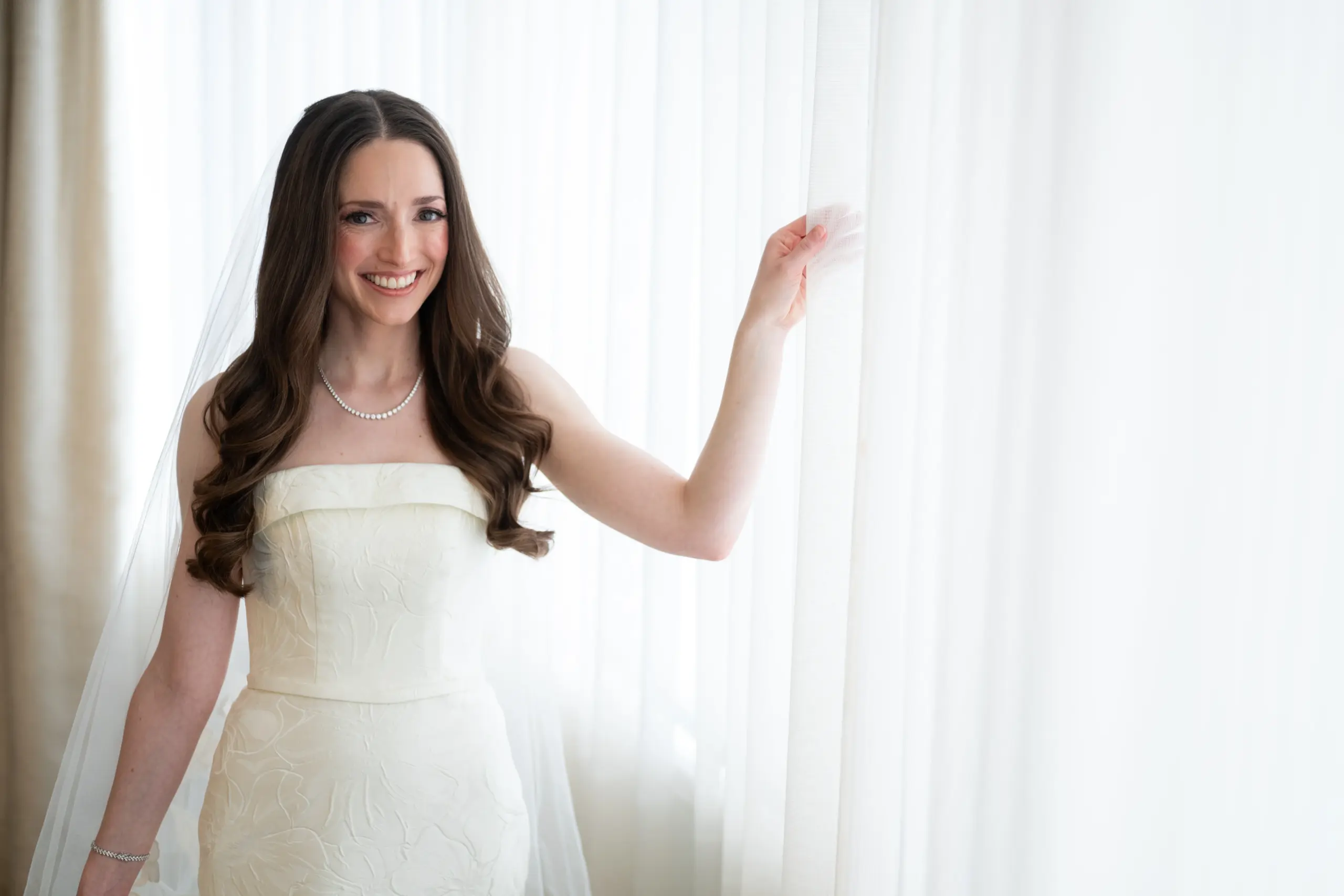 Bride styled with fine jewelry complementing her wedding dress neckline